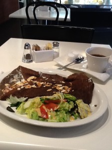 Photo of brown crepe with vegetable side and coffee